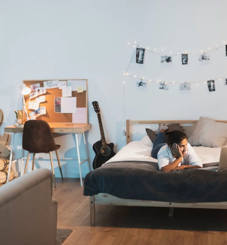 Genç Odası Dekorasyon Trendleri 2025 9 woman staying bed looking laptop scaled